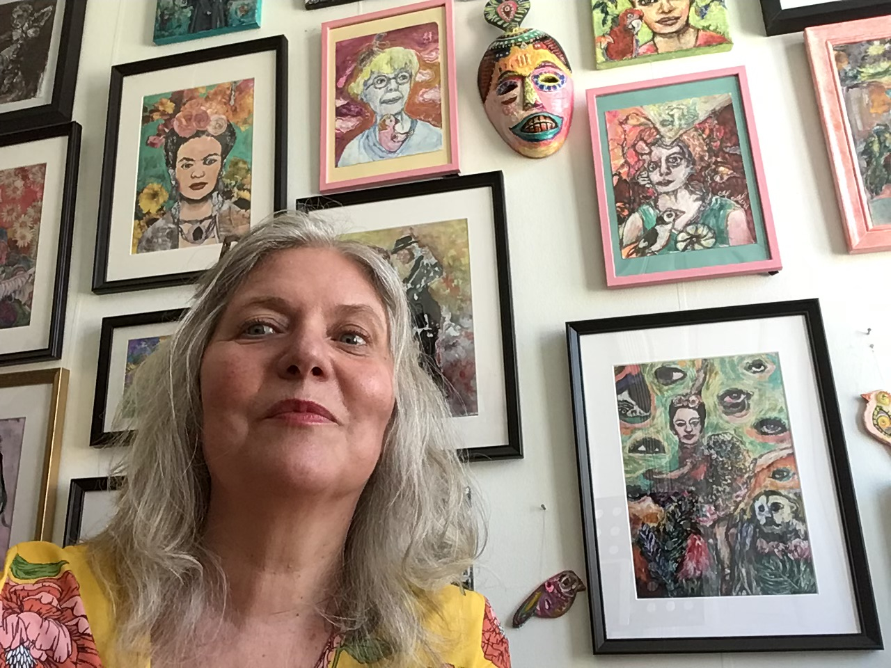 Mette Munch med hendes kunst i baggrunden